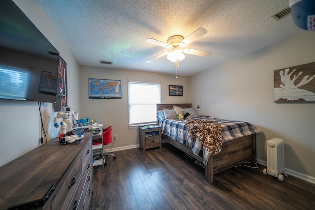 bedroom featuring dark wood-style floors, radiator heating unit, visible vents, and a ceiling fan