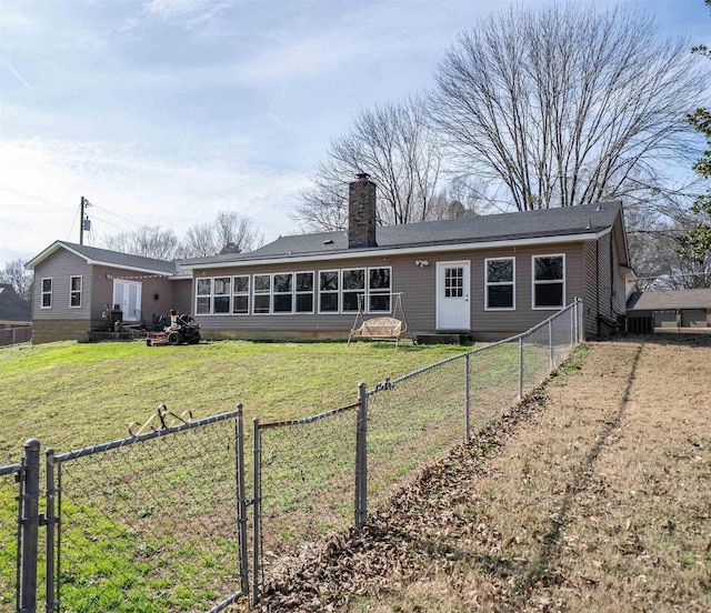 back of property with entry steps, fence private yard, a sunroom, a yard, and a chimney