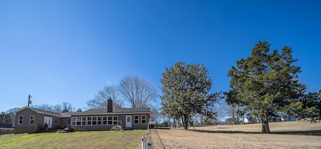 ranch-style home featuring a chimney and a front yard
