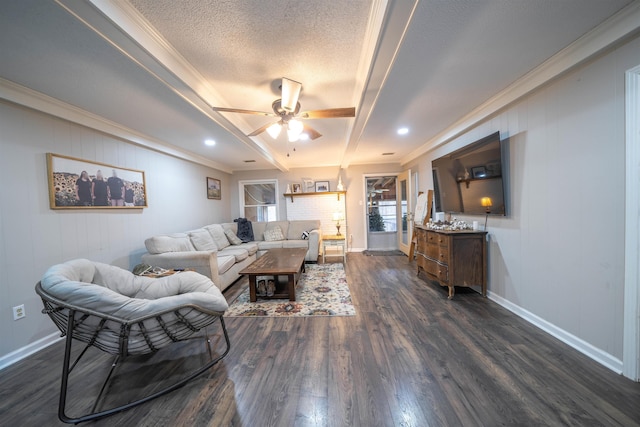 living area with a textured ceiling, dark wood finished floors, a ceiling fan, and baseboards