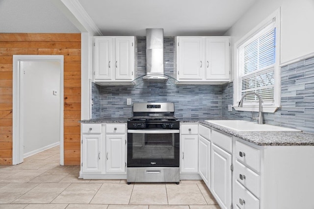 kitchen featuring white cabinetry, sink, light stone countertops, stainless steel range with gas stovetop, and wall chimney exhaust hood