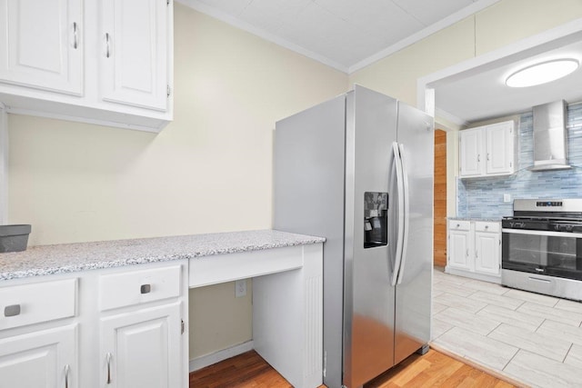 kitchen featuring wall chimney exhaust hood, tasteful backsplash, crown molding, stainless steel appliances, and white cabinets