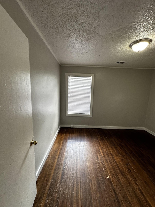 empty room with dark wood-type flooring and a textured ceiling