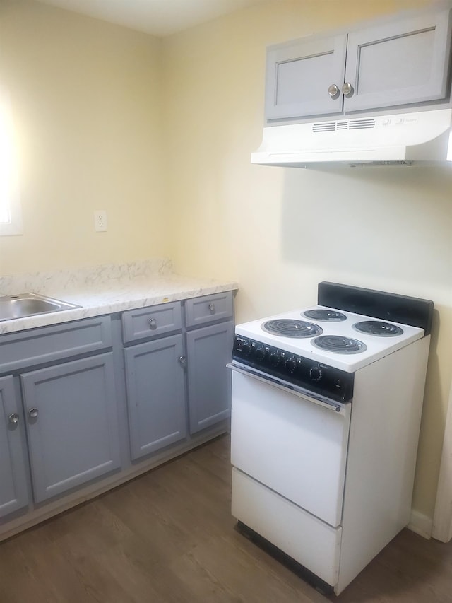 kitchen with dark hardwood / wood-style flooring, white electric range oven, gray cabinets, and sink