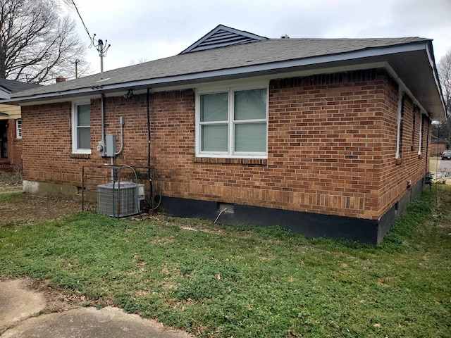 view of home's exterior featuring central AC unit and a lawn