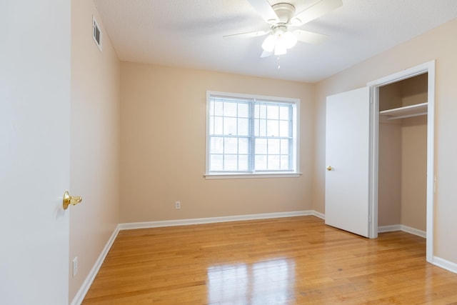 unfurnished bedroom featuring ceiling fan, a textured ceiling, and light wood-type flooring