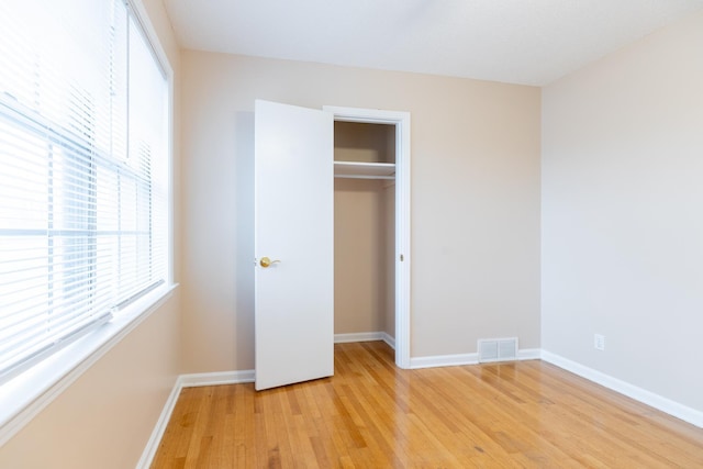 unfurnished bedroom with light hardwood / wood-style flooring and a closet