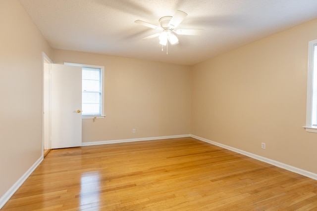 unfurnished room with a textured ceiling, light hardwood / wood-style floors, and ceiling fan