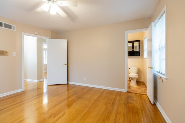 unfurnished bedroom featuring connected bathroom, ceiling fan, and light wood-type flooring