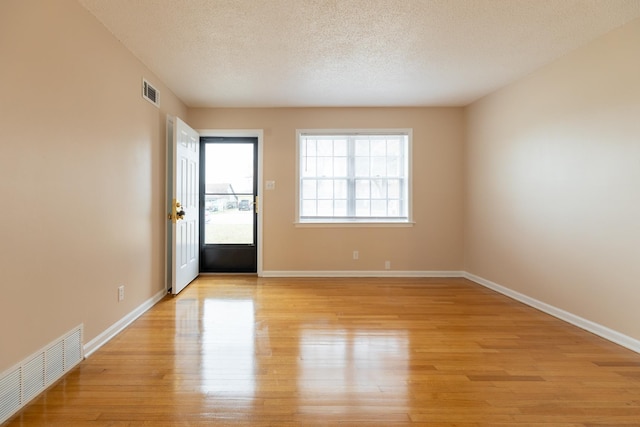 interior space featuring a textured ceiling and light wood-type flooring