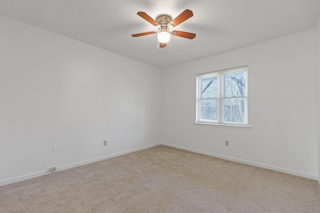 carpeted empty room featuring ceiling fan and a textured ceiling