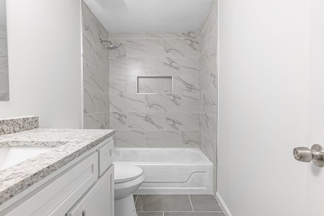 full bathroom with vanity, a textured ceiling, tile patterned floors, toilet, and tiled shower / bath