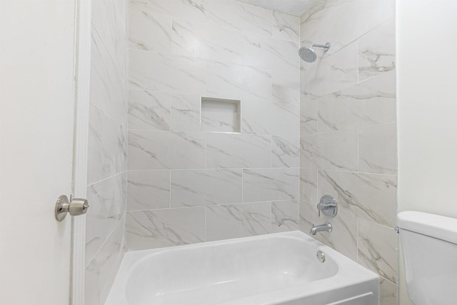 bathroom featuring toilet and tiled shower / bath combo