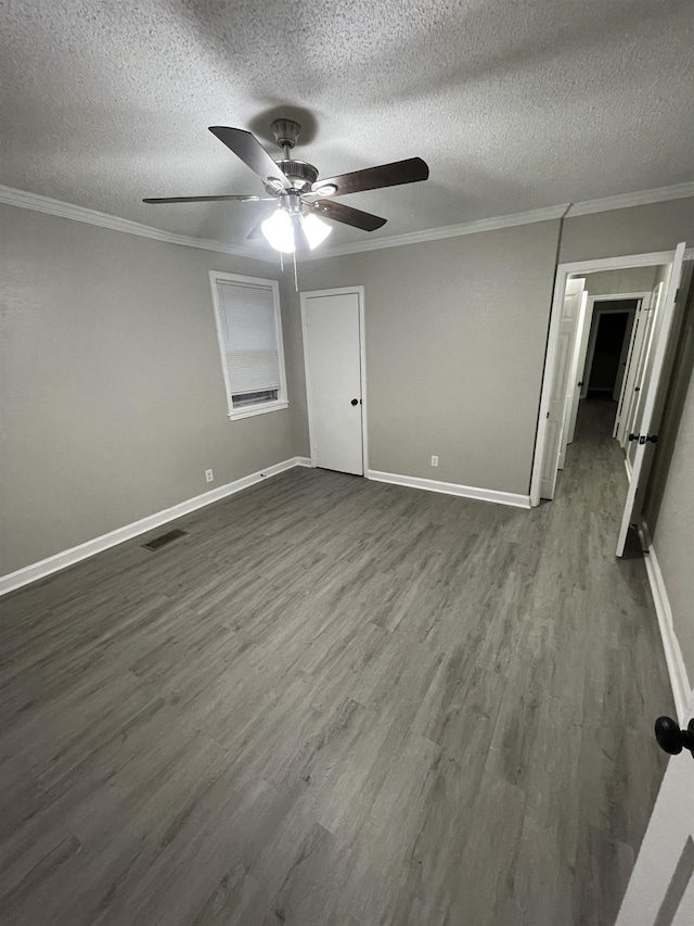 unfurnished bedroom featuring ceiling fan, ornamental molding, dark hardwood / wood-style floors, and a textured ceiling