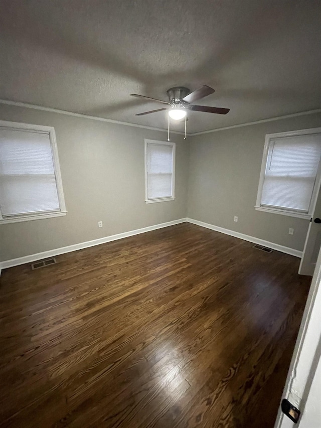 unfurnished room featuring ceiling fan, ornamental molding, dark hardwood / wood-style floors, and a textured ceiling