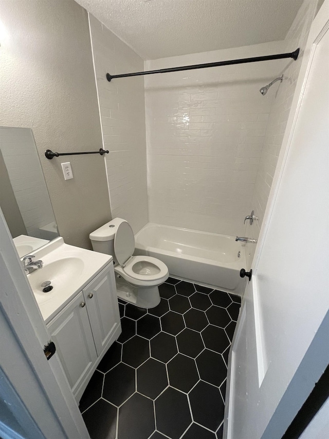 full bathroom with tile patterned flooring, tiled shower / bath combo, vanity, a textured ceiling, and toilet