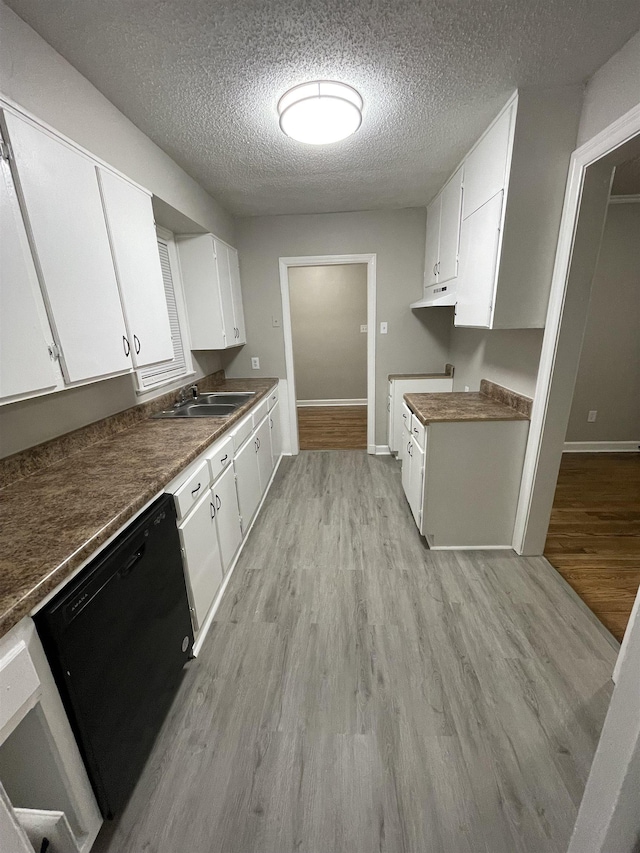 kitchen featuring sink, white cabinetry, a textured ceiling, black dishwasher, and light hardwood / wood-style floors