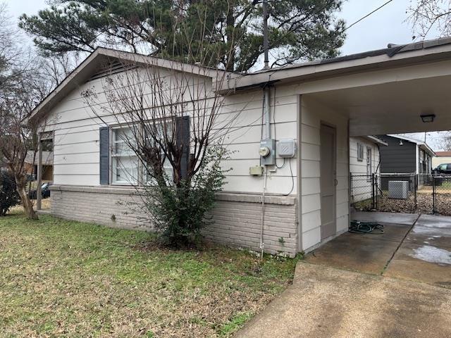 view of side of home with a carport and a yard