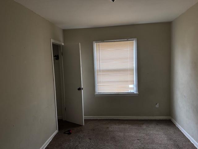 empty room with dark colored carpet