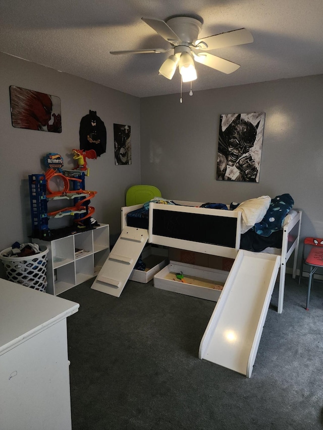 bedroom featuring ceiling fan, dark carpet, and a textured ceiling