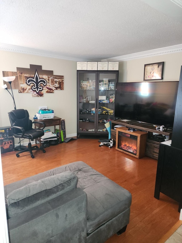 living room with hardwood / wood-style flooring, ornamental molding, and a textured ceiling