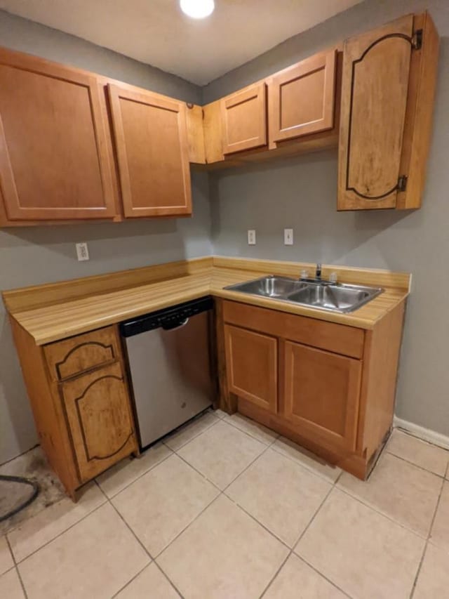 kitchen featuring sink, light tile patterned floors, and stainless steel dishwasher