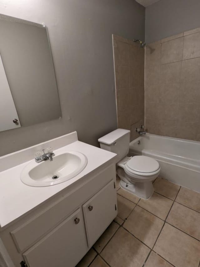 full bathroom featuring tile patterned flooring, vanity, toilet, and tiled shower / bath