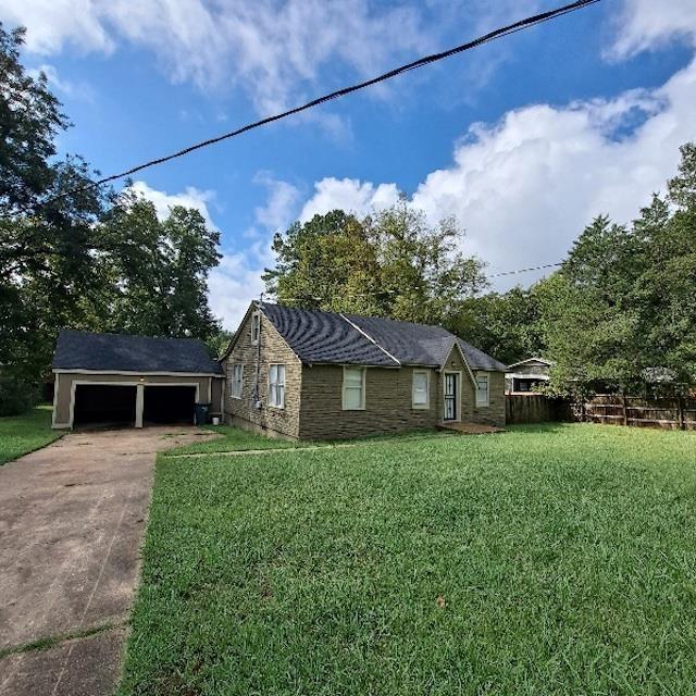 view of front of home with an outbuilding, a garage, and a front yard