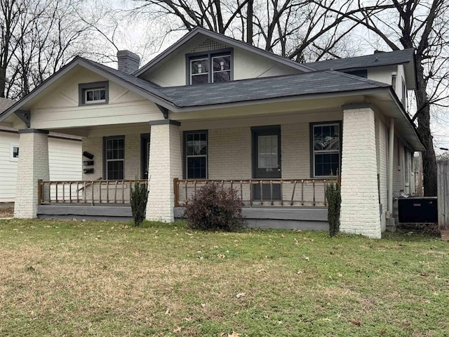 bungalow featuring covered porch and a front lawn