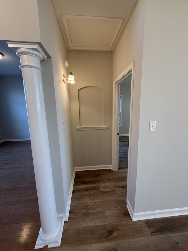 hall featuring dark hardwood / wood-style floors and ornate columns