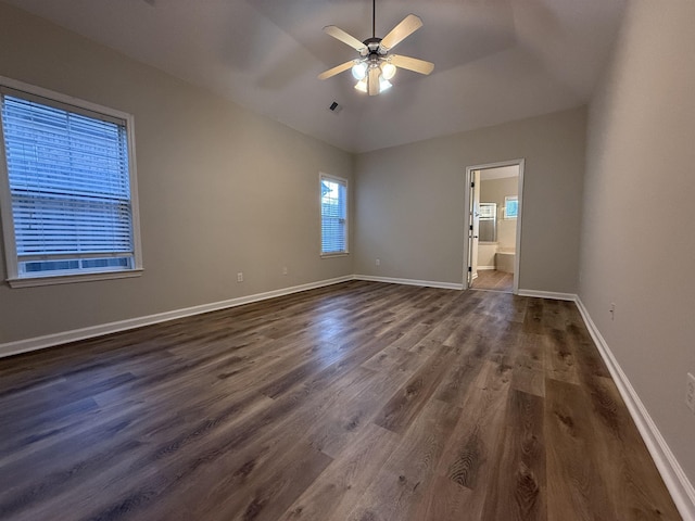 spare room with vaulted ceiling, dark hardwood / wood-style floors, and ceiling fan