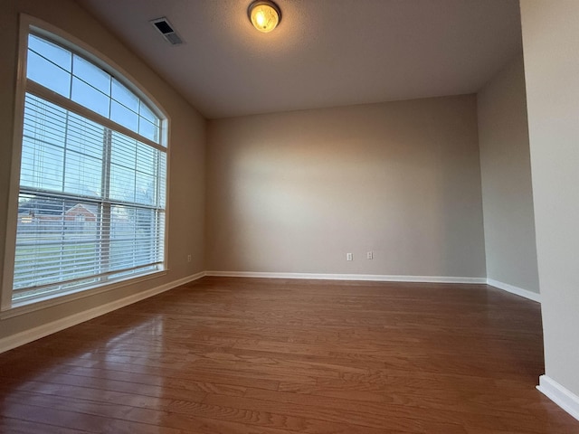 empty room with dark hardwood / wood-style flooring