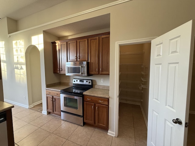 kitchen featuring stainless steel appliances and light tile patterned flooring