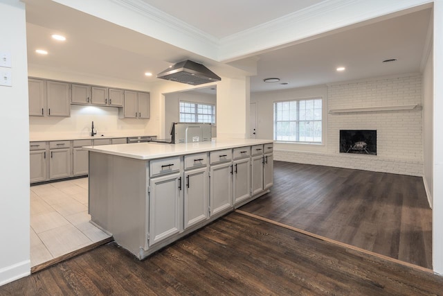 kitchen featuring crown molding, a center island, gray cabinetry, and dark hardwood / wood-style floors