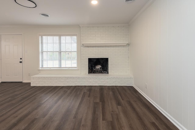 unfurnished living room with dark wood-type flooring, ornamental molding, and a fireplace