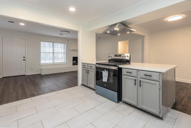 kitchen featuring crown molding, gray cabinets, extractor fan, stainless steel electric range oven, and kitchen peninsula