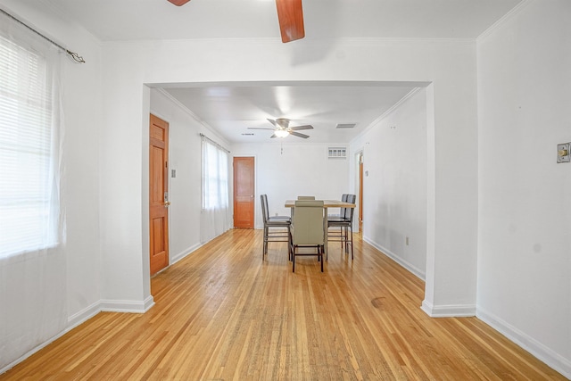 dining room with ceiling fan, ornamental molding, and light wood-type flooring