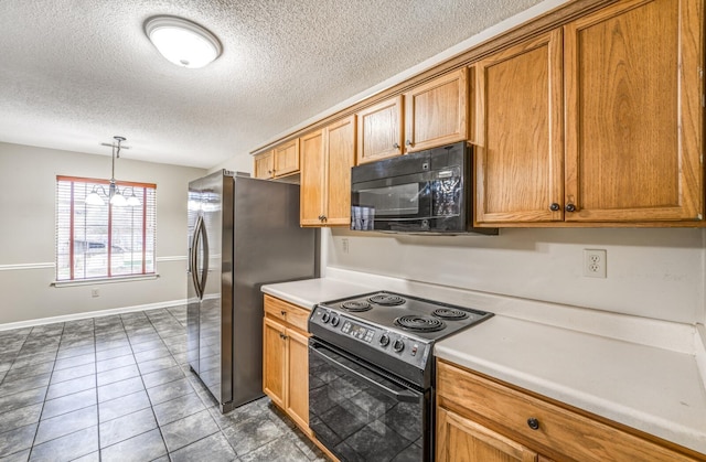 kitchen featuring pendant lighting, dark tile patterned flooring, a textured ceiling, and black appliances