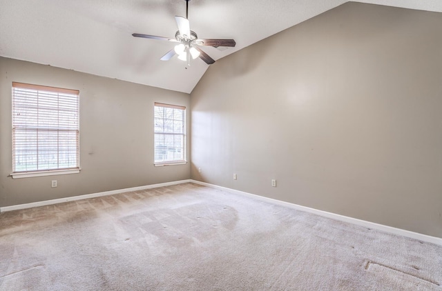 carpeted empty room with vaulted ceiling and ceiling fan