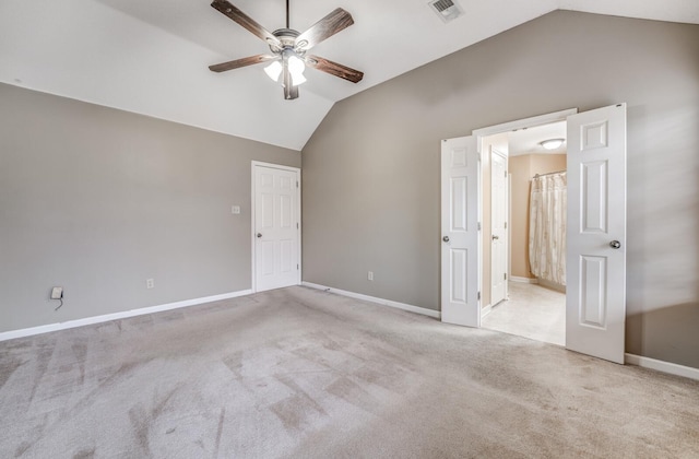 carpeted spare room featuring ceiling fan and vaulted ceiling