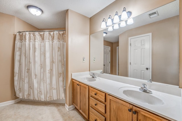 bathroom with vanity, tile patterned flooring, a shower with curtain, and a textured ceiling