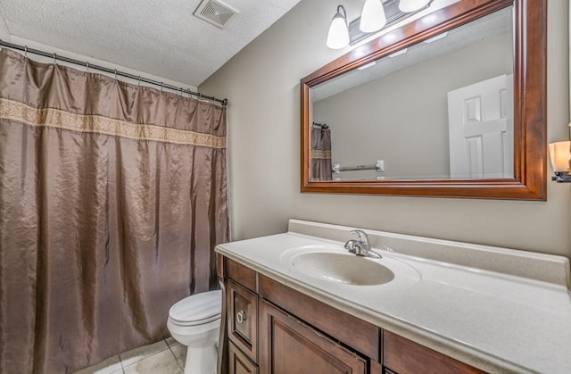 bathroom with tile patterned floors, toilet, vanity, and a textured ceiling