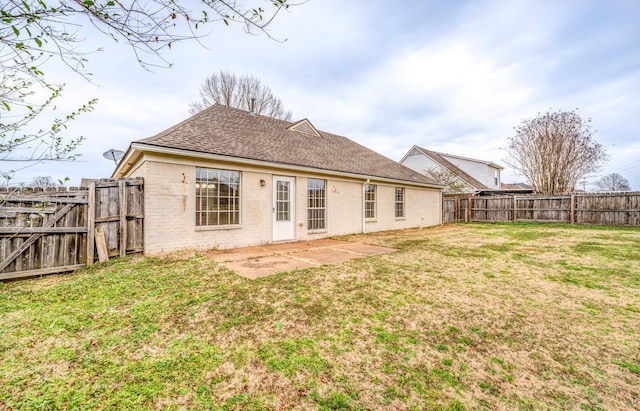 rear view of property featuring a yard and a patio area