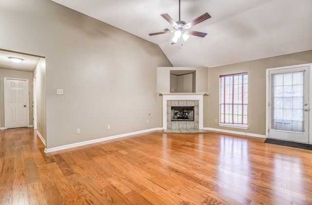 unfurnished living room with lofted ceiling, a fireplace, light hardwood / wood-style floors, and ceiling fan