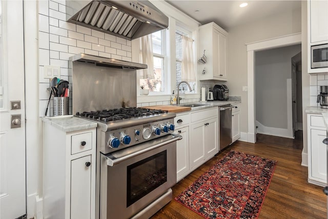 kitchen with sink, white cabinetry, tasteful backsplash, stainless steel appliances, and wall chimney range hood