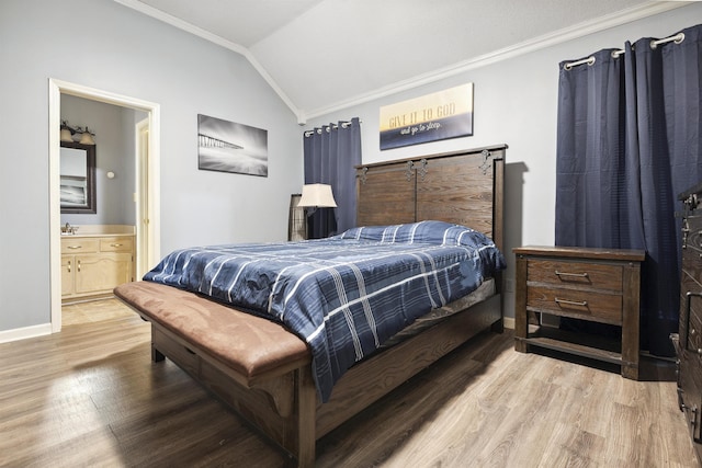 bedroom featuring hardwood / wood-style flooring, vaulted ceiling, ornamental molding, and ensuite bathroom