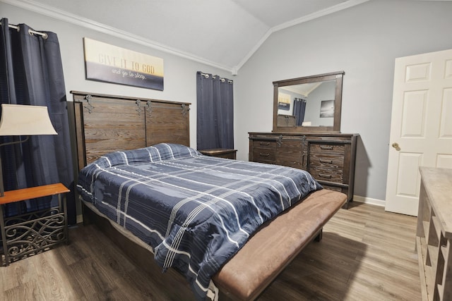 bedroom featuring hardwood / wood-style floors, vaulted ceiling, and ornamental molding