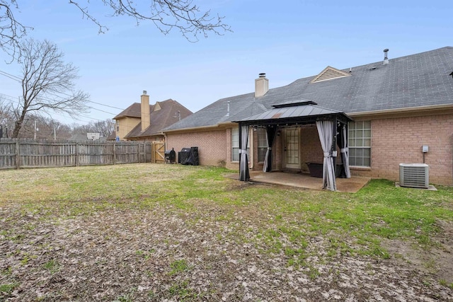 back of house with cooling unit, a gazebo, a lawn, and a patio area