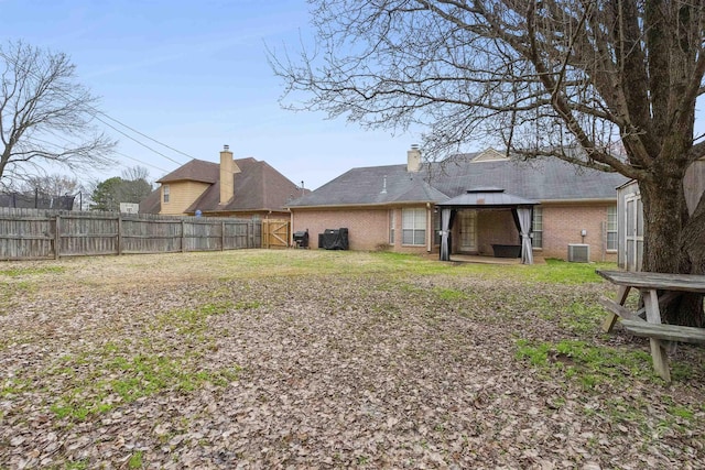 back of property featuring a gazebo and central AC