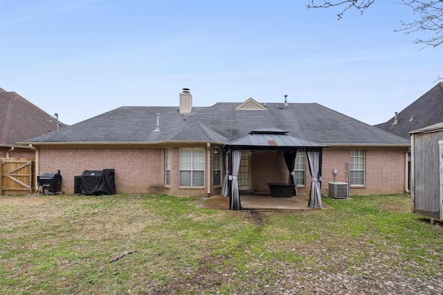 rear view of property with a gazebo, a yard, central air condition unit, and a patio